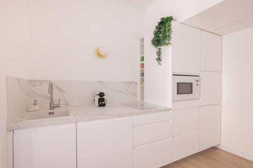 - une cuisine blanche avec des placards blancs et un évier dans l'établissement Paca Properties - 2MD - Beau T2, à Cannes