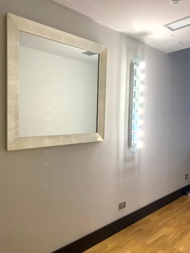 a mirror on a white wall with a window at MH Design Hotel in Naples