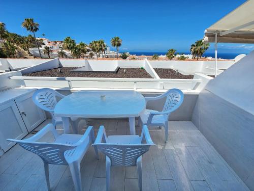 una mesa y sillas en un balcón con vistas a la playa en Atlantic Mirage Island Village, en Adeje