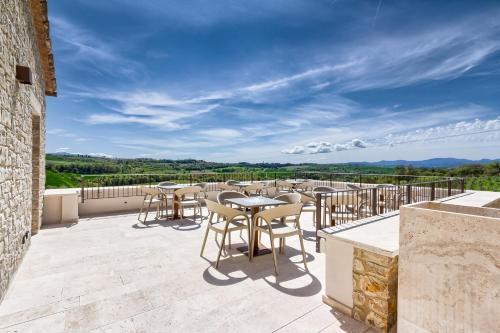 a patio with tables and chairs on a balcony at Agriturismo Colli Martani in Massa Martana