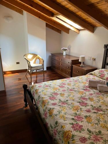 グラヴェドーナにあるAppartamento Soniaのベッドルーム1室(ベッド1台、椅子、ドレッサー付)