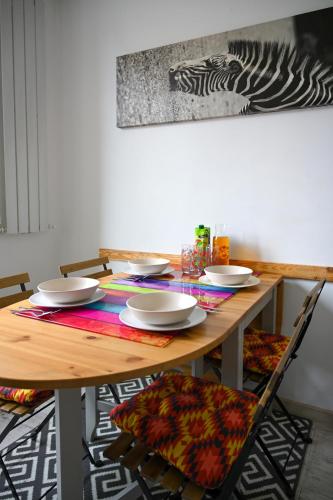 a wooden table with chairs and plates on it at House with lanterns in Tychy