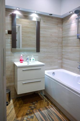 a bathroom with a sink and a bath tub and a mirror at House with lanterns in Tychy