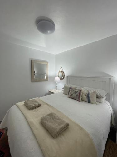 a bedroom with a large white bed with two towels on it at Bougain Villa Studio 1 in Paternoster