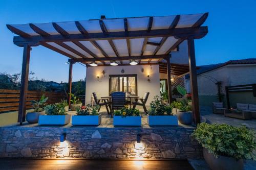 a patio with a wooden pergola at Villa Filyra in Kato Gatzea