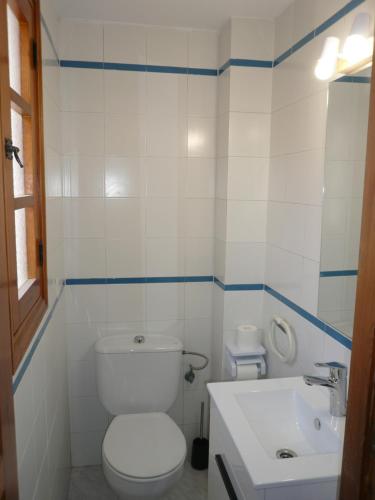 La salle de bains blanche est pourvue de toilettes et d'un lavabo. dans l'établissement Inocencia, à Alcossebre