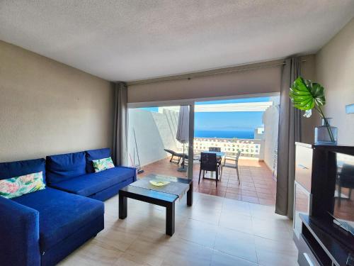 a living room with a blue couch and a table at Ocean View Villas Canarias in Adeje