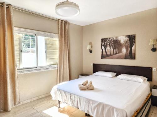 Un dormitorio con una cama con un osito de peluche. en Ocean View Villas Canarias, en Adeje
