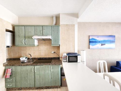 a kitchen with green cabinets and a sink at Ocean View Villas Canarias in Adeje