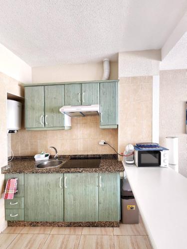 a kitchen with green cabinets and a white counter top at Ocean View Villas Canarias in Adeje