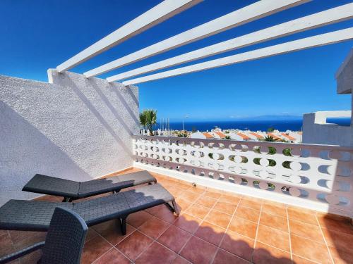 a balcony with two benches and a view of the ocean at Ocean View Villas Canarias in Adeje