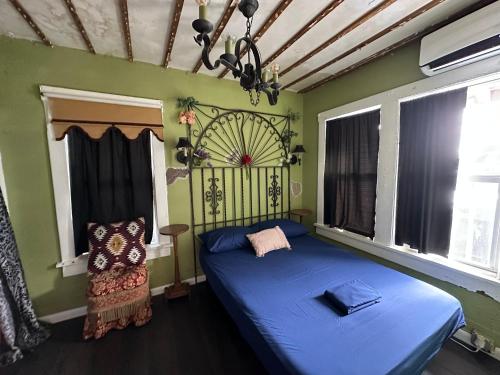 a bedroom with a blue bed and a chair at OQP Vacations Cottage in Miami