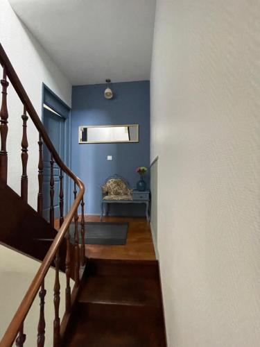 a stairway with blue walls and a couch in a room at Villa Artiz in Dunkerque