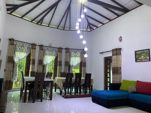 ein Wohnzimmer mit einem Tisch und einem blauen Sofa in der Unterkunft White Win Villa in Elewala