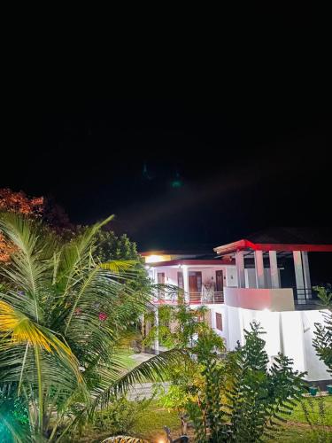 a white building with a red roof at night at White Win Villa in Elewala