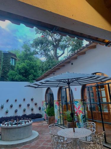 a patio with two tables and an umbrella at Sierra Norte By Chic Hotel Group in Tepoztlán