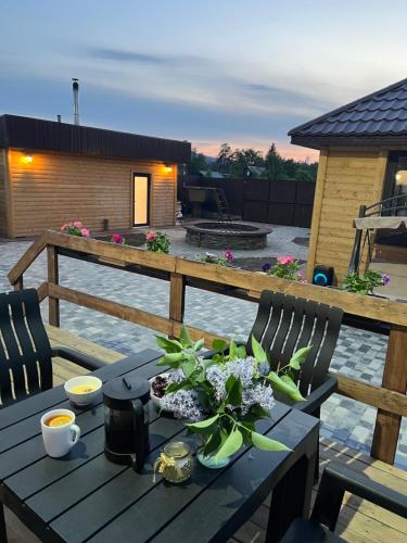 a wooden table with flowers on top of a patio at По Щучьему Велению in Shchūchīnsk