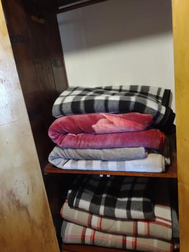 una pila de toallas en una estantería de madera en Flats Brancas Nuvens, en Campos do Jordão