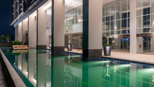 a pool in the middle of a building at night at Apartemen Altiz Bintaro J in Mencil