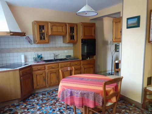 une cuisine avec une table recouverte d'une nappe rose dans l'établissement Gite 32 rue du huit mai, à Freneuse