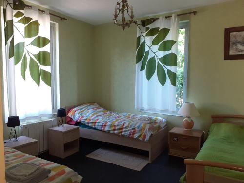 ein Schlafzimmer mit einem Bett und einem Fenster mit Blättern an der Wand in der Unterkunft Gite 32 rue du huit mai in Freneuse