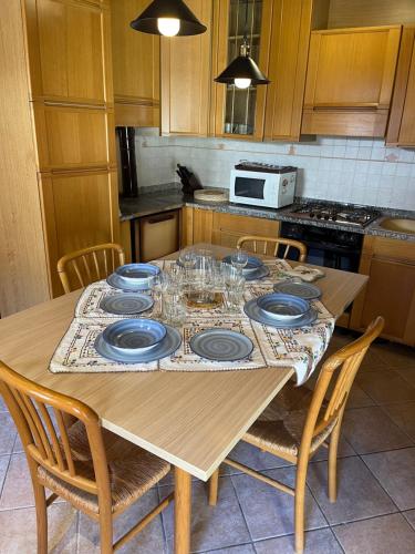uma mesa com pratos e copos na cozinha em Mida & Lino' s House casa rustica em Solagna