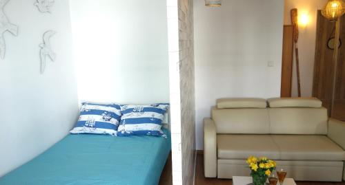 een kamer met een bed, een bank en een stoel bij Studio Lu Bernadowska - balkon ogródek parking, 800m morze in Sopot