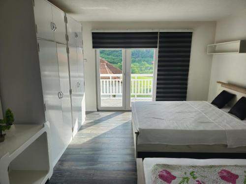 a bedroom with a bed and a view of a balcony at Rooms Mery in Visoko