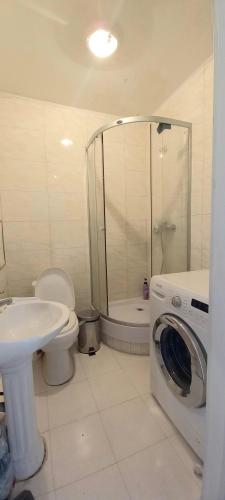 a bathroom with a toilet a sink and a washing machine at Tsatsa in Ulaanbaatar