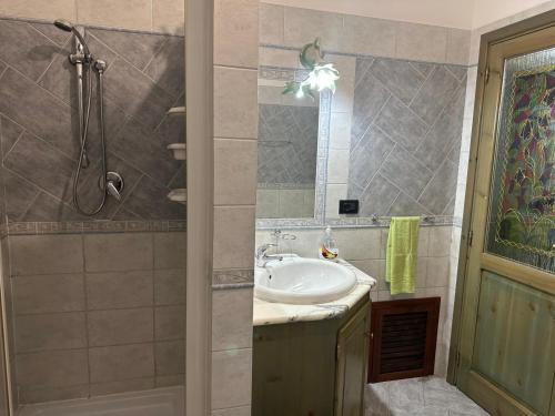 y baño con lavabo y ducha. en Appartamento Picasso, en Cala Gonone
