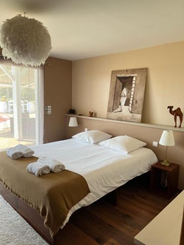 une chambre avec un grand lit avec des draps blancs dans l'établissement Calme et détente à 4 km de l’ocean, à Saint-Julien-en-Born