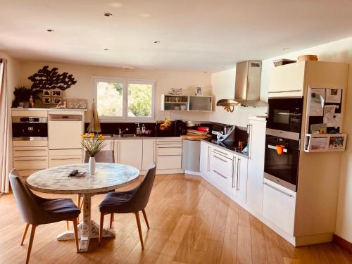 une cuisine avec une table et des chaises dans l'établissement Calme et détente à 4 km de l’ocean, à Saint-Julien-en-Born