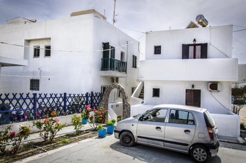 a small car parked in front of a white building at Christina Rooms in Adamas