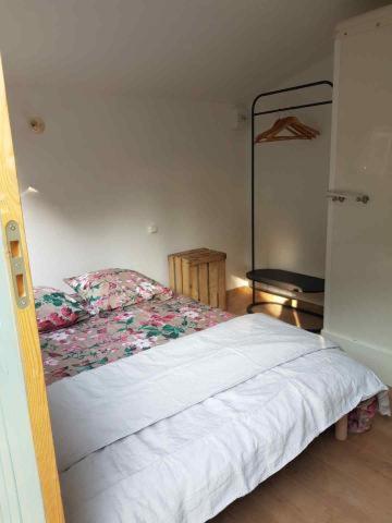 une chambre avec un lit blanc avec des fleurs dessus dans l'établissement La cabane de Mimi la Sardine, à Saint-Gervais en-Belin