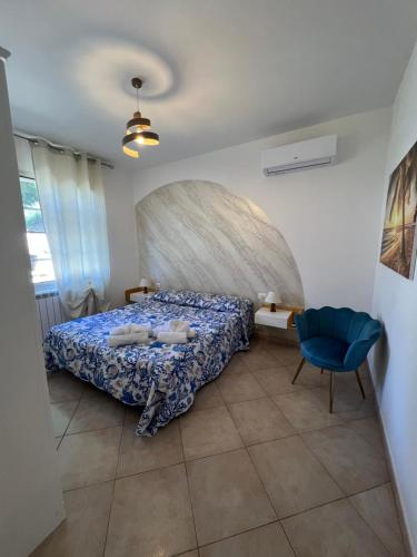 een slaapkamer met een bed en een blauwe stoel bij Casa Serena in Capoliveri