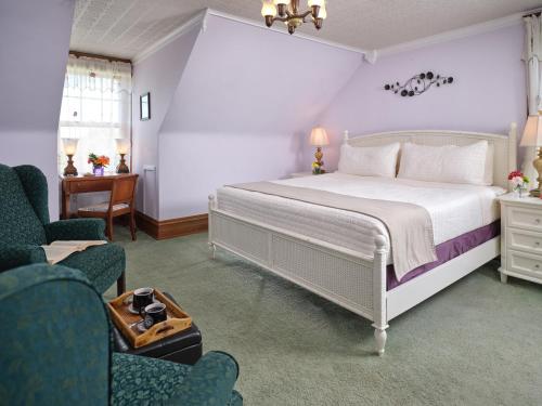 1 dormitorio con 1 cama blanca y 2 sillas en Keystone Inn Bed and Breakfast, en Gettysburg