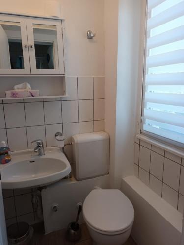 a white bathroom with a toilet and a sink at Doppelbungalow Ostsee Nr. 8 + 9 in Ahlbeck