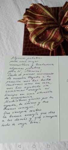 a handwritten letter with a bow on top at Pensión Casa do Gallo Sarria in Sarria