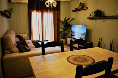 a living room with a couch and a table and a tv at Apartamento Zaranda in Daimiel