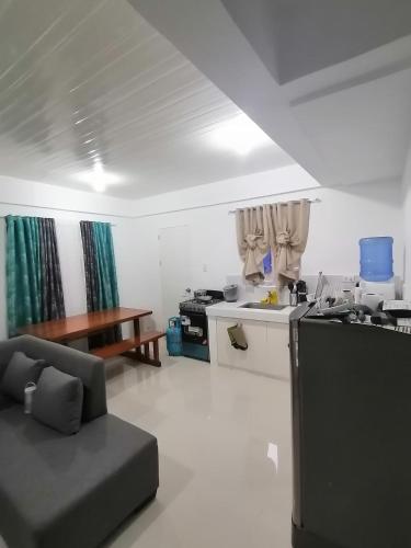 a kitchen and living room with a couch and a table at CAMILA Homes Transient house /vacation house in Butuan