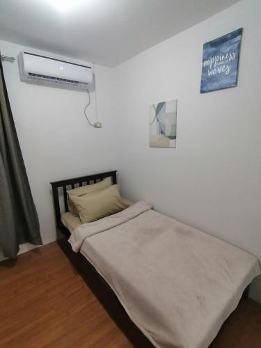 Dormitorio pequeño con cama y aire acondicionado en CAMILA Homes Transient house /vacation house, en Butuán