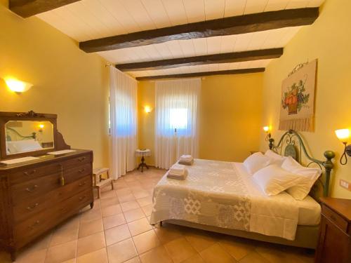 Schlafzimmer mit einem Bett, einer Kommode und einem Spiegel in der Unterkunft La Luna di Mezzanotte in Fratta Todina