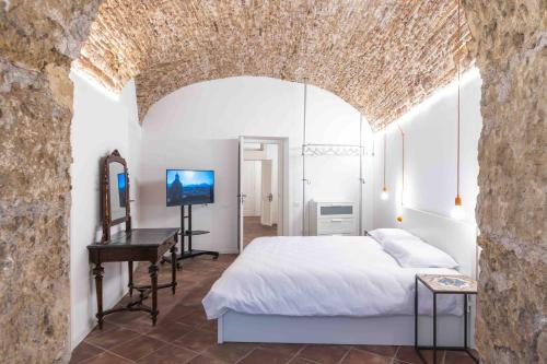 sypialnia z łóżkiem i biurkiem w pokoju w obiekcie Calderai 82 suites 1 e 2 w mieście Palermo