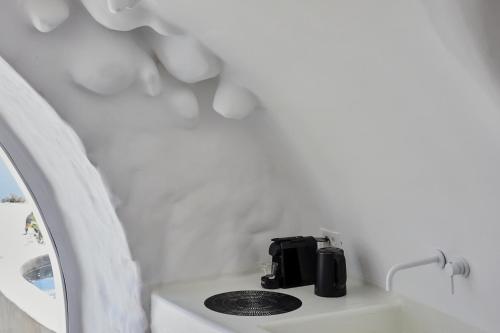 a coffee maker sitting on a counter in a white room at Theano Cave Suites & Villas in Imerovigli