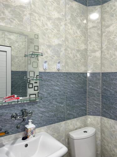 a bathroom with a sink and a toilet and a mirror at Roman's guest house in Garni in Garni