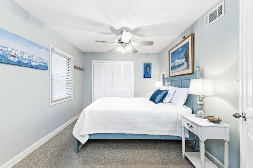 a blue bedroom with a bed and a ceiling fan at Clearwater 1D in Gulf Shores