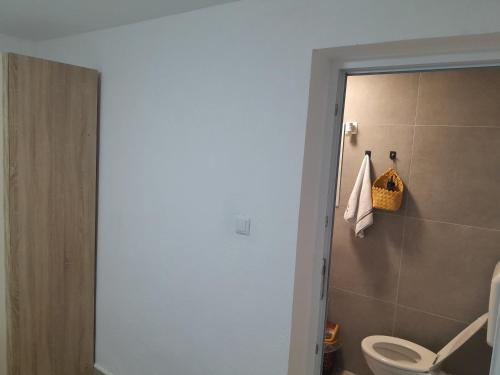 a bathroom with a white toilet and a shower at Apartmani BET Gradačac 1 Maj broj 24 in Gradačac