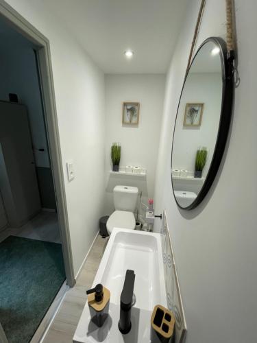 a bathroom with a white tub and a mirror at Villa Artiz in Dunkerque