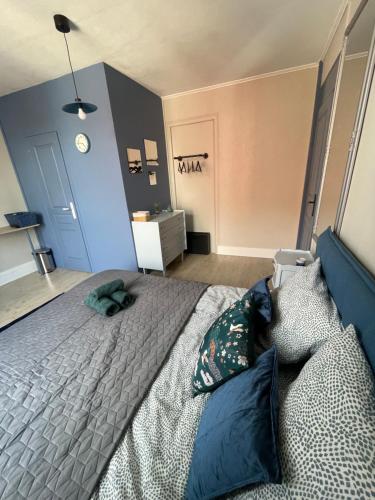 a bedroom with a large bed with blue pillows at Villa Artiz in Dunkerque