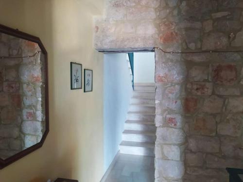 a stairway with a mirror and a stone wall at House Mare & Supramonte in Baunei